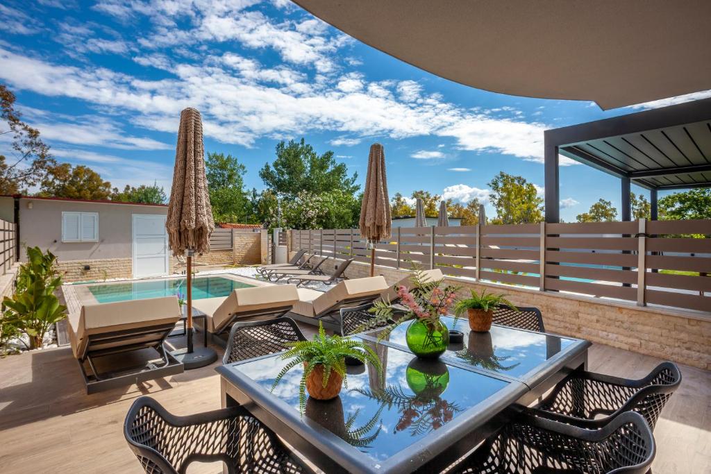 a patio with a table and chairs and a pool at Villa Olia with private pool in Pefkochori