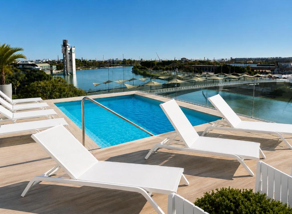 a swimming pool with white lounge chairs on a roof at Ribera de Triana Hotel in Seville