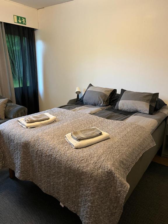 a bedroom with a bed with two towels on it at Kangaskartano in Keitelepohja