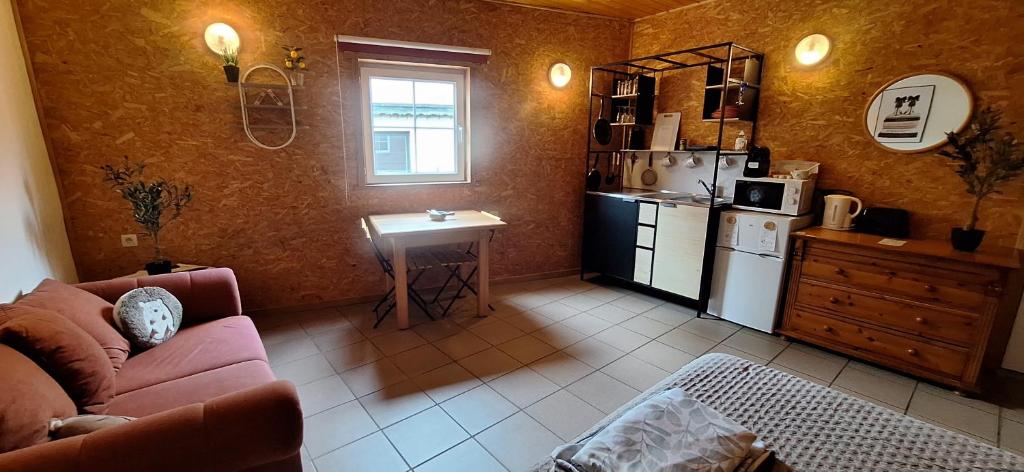 a living room with a couch and a kitchen at Chez Chou-Vrac & Ciboulette in Durbuy