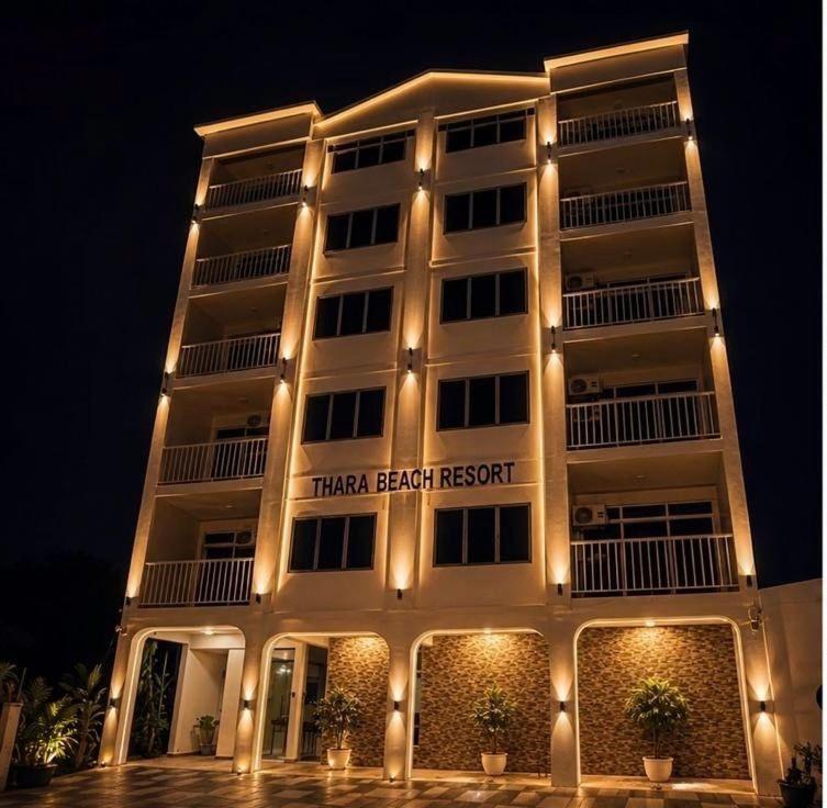 a building with a sign that reads that beach resort at Thara Beach Resort in Kampong Pasir Bogak
