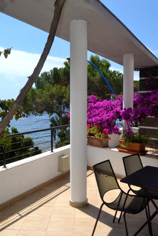 a balcony with a table and chairs and flowers at Hotel Cala Luna in Cala Gonone