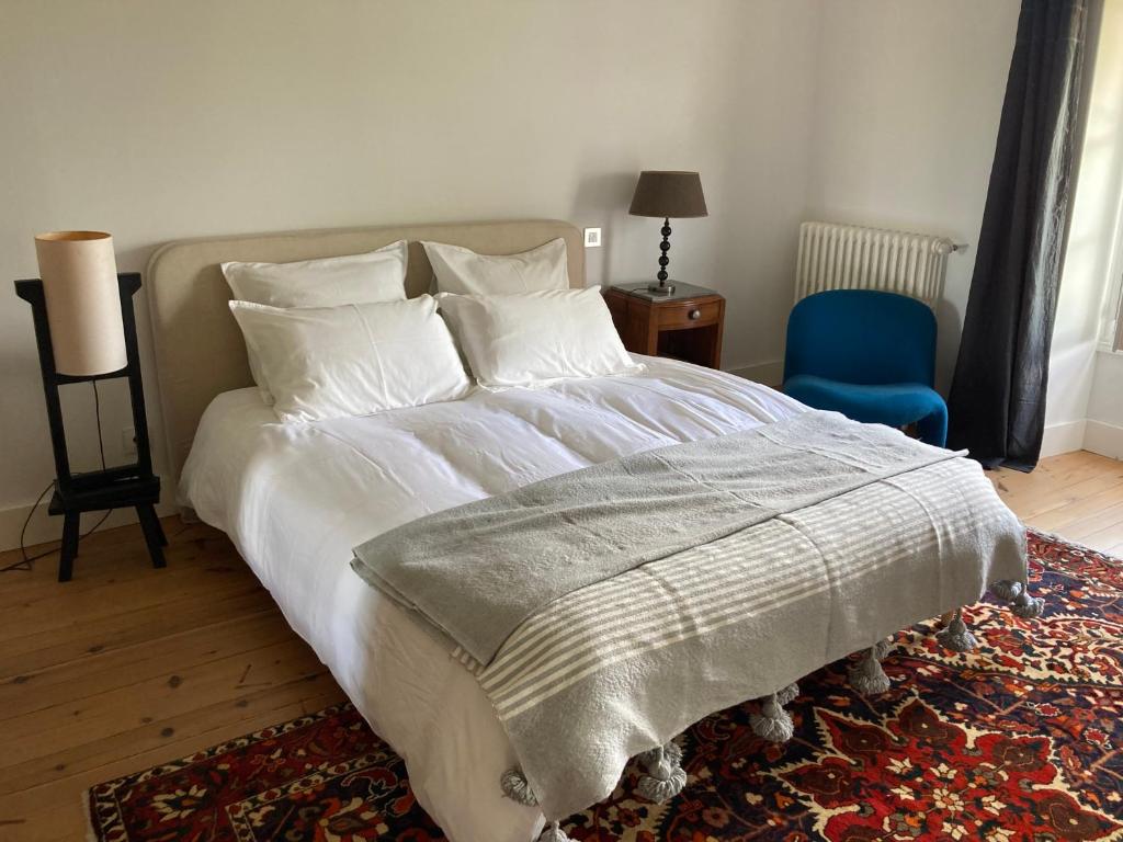 a bedroom with a large bed and a blue chair at Maralocquet in Barbezieux-Saint-Hilaire