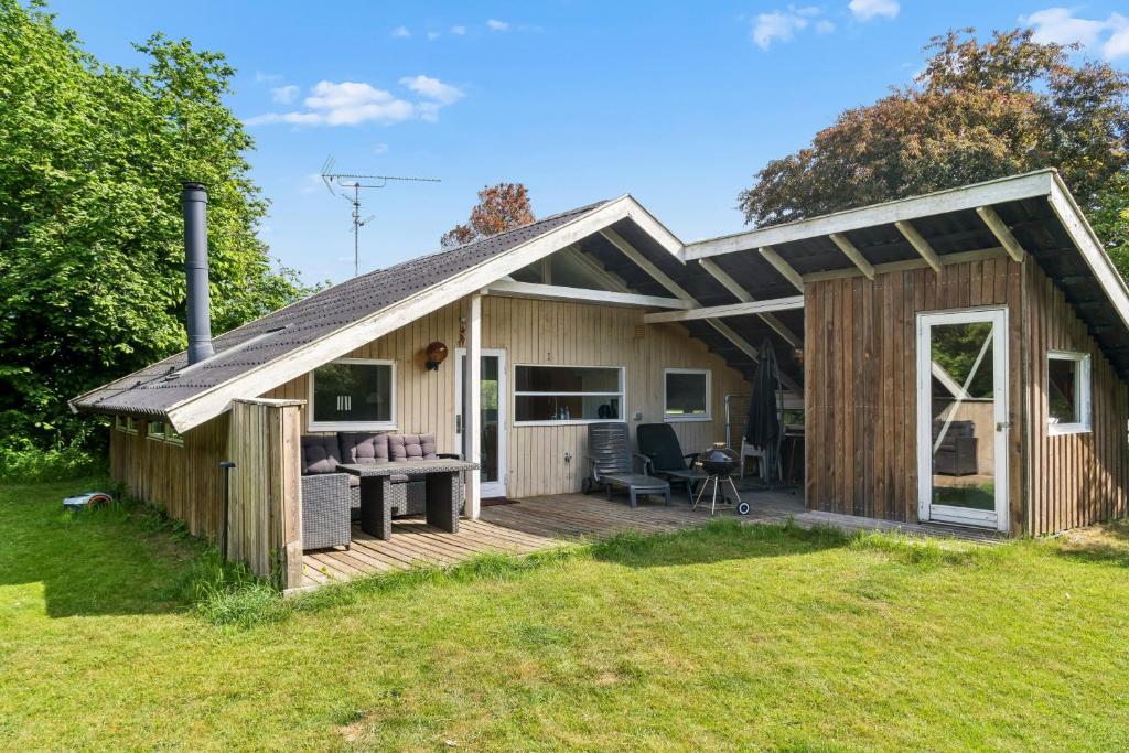 a house with a deck and a patio at Charming Cottage Near The Water in Holbæk