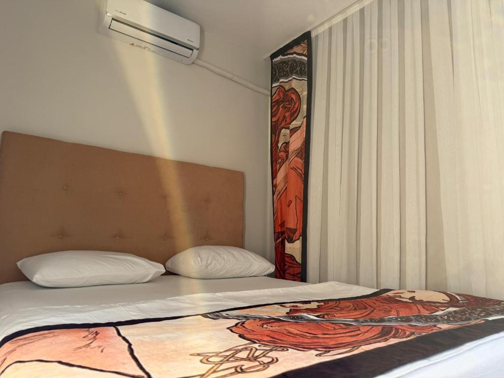 a bedroom with a bed with a painting on the wall at Cnr in Manavgat