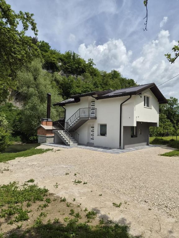 a white house with a staircase on the side at Apartmani Lucica in Jajce