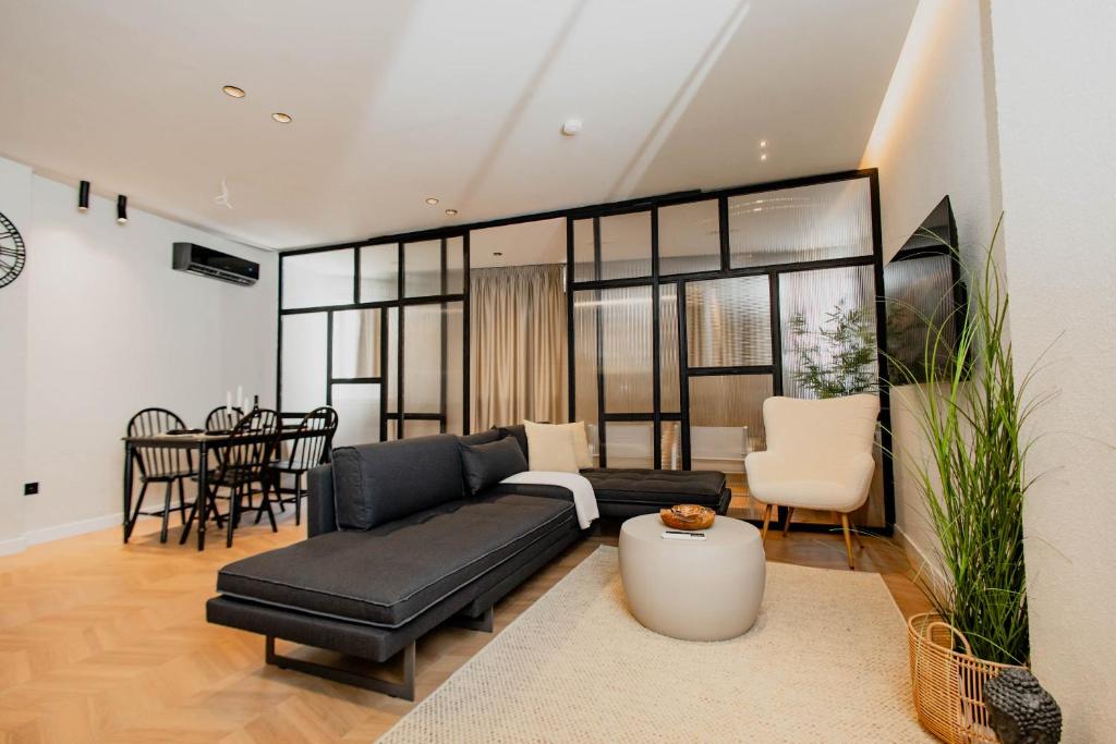 a living room with a black couch and a table at Maison Sidra in Thessaloniki