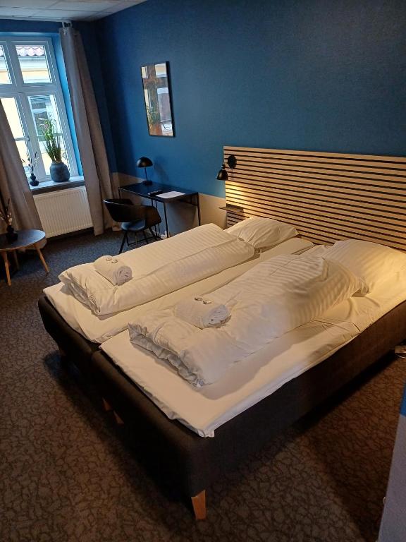 a large bed in a bedroom with a blue wall at Double room 5 in the center of Saeby in Sæby