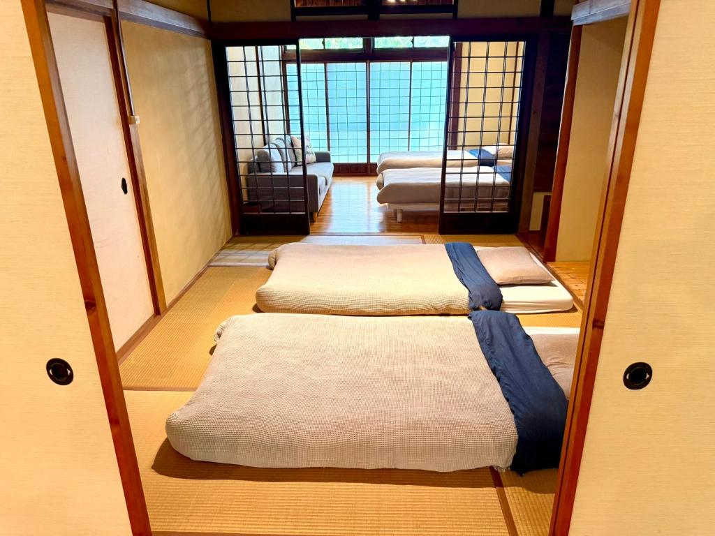a room with four beds in a room with a mirror at SADO Stay 02 金山京町一軒家貸し切り in Sado