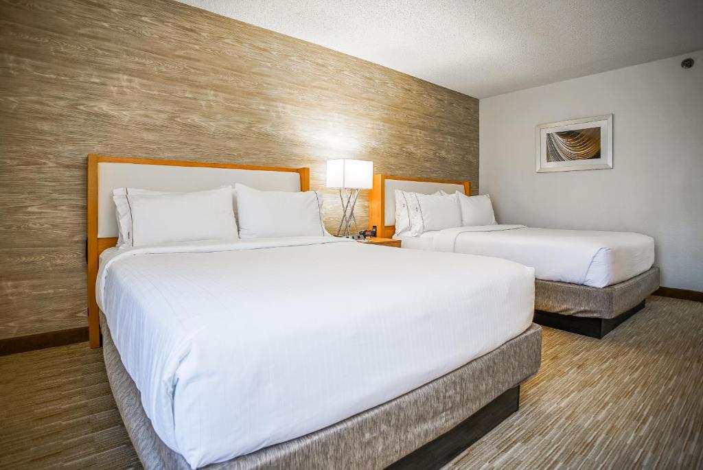 two beds in a hotel room with white sheets at Sleep Inn & Suites in Memphis