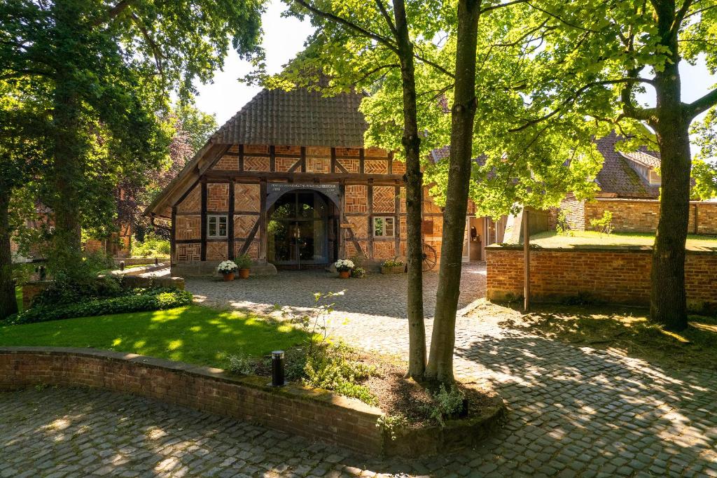 a large brick building with an archway in a yard at Biohotel WildLand Natural Resort in Hornbostel