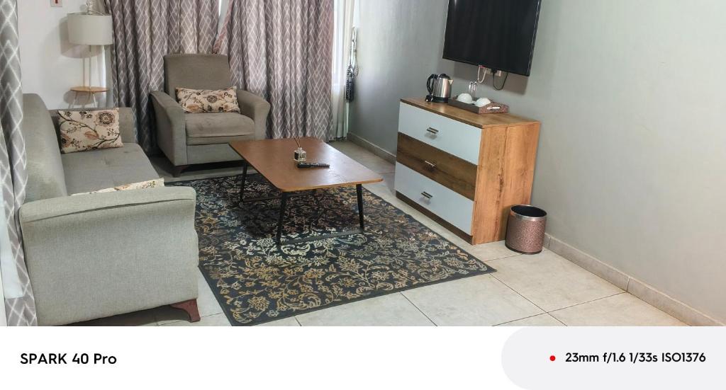 a living room with a chair and a table at Peach City Hotel in Prampram