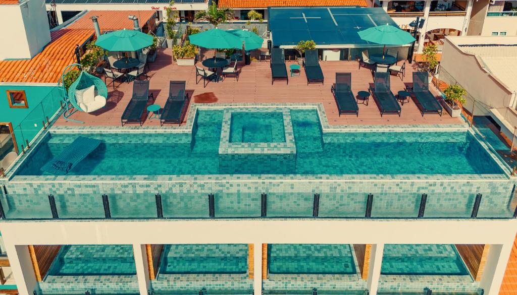 an overhead view of a swimming pool with chairs and umbrellas at Pousada Antonella in Morro de São Paulo