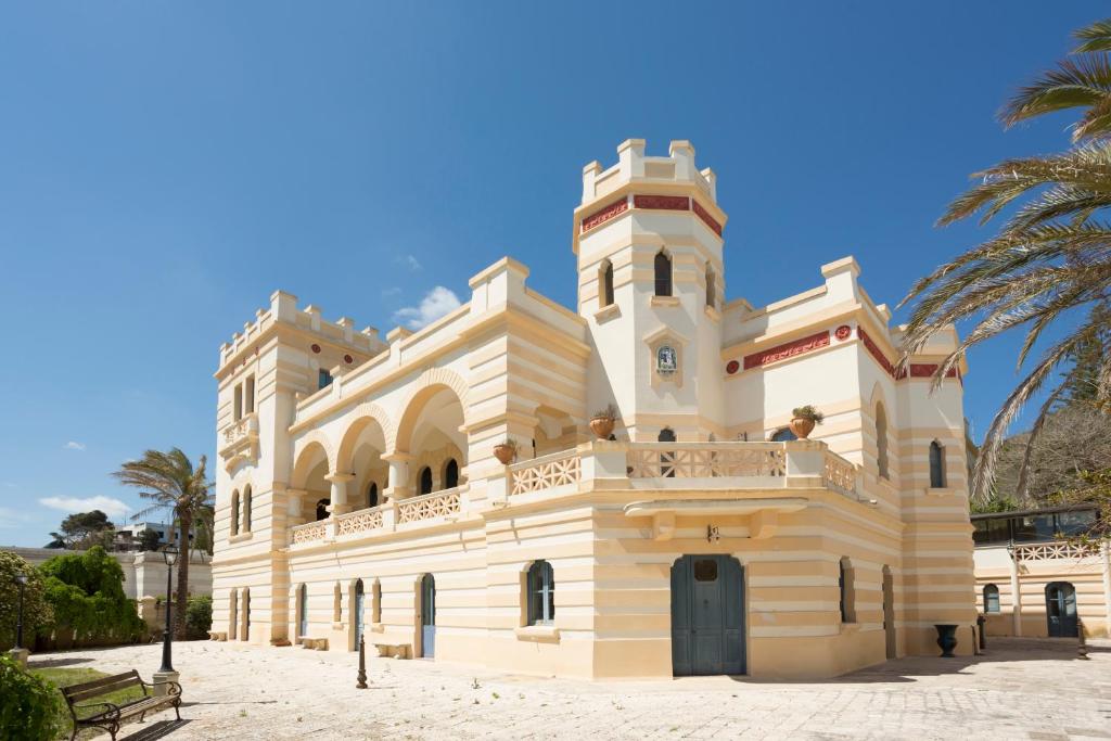 a large white building with a palm tree at Villa Raffaella in Santa Cesarea Terme