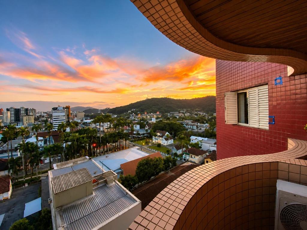 a building with a view of a city at sunset at Apê completo bem no centro in Joinville