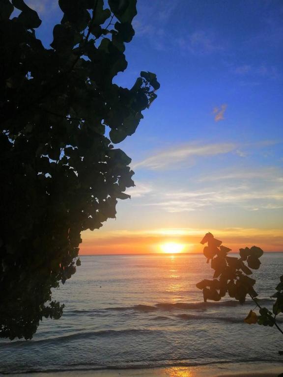 a person riding a horse on the beach at sunset at Changbar Bungalow in Ban Ao Sapparot