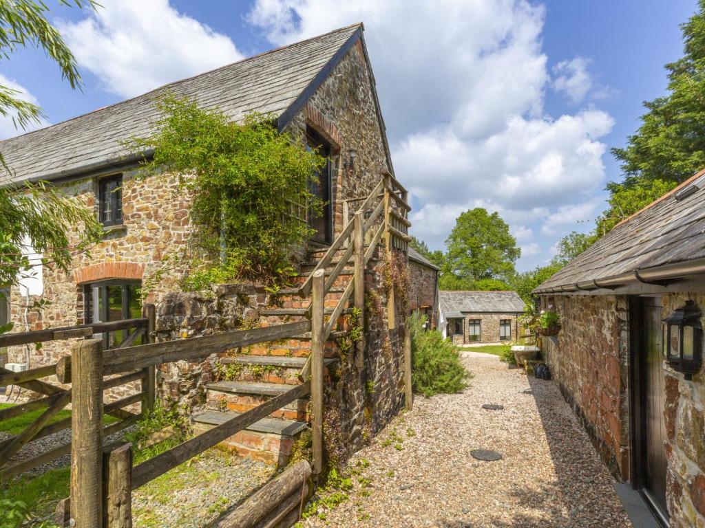 an old stone house with a wooden fence at Apartment The Appleloft suite by Interhome in Holsworthy