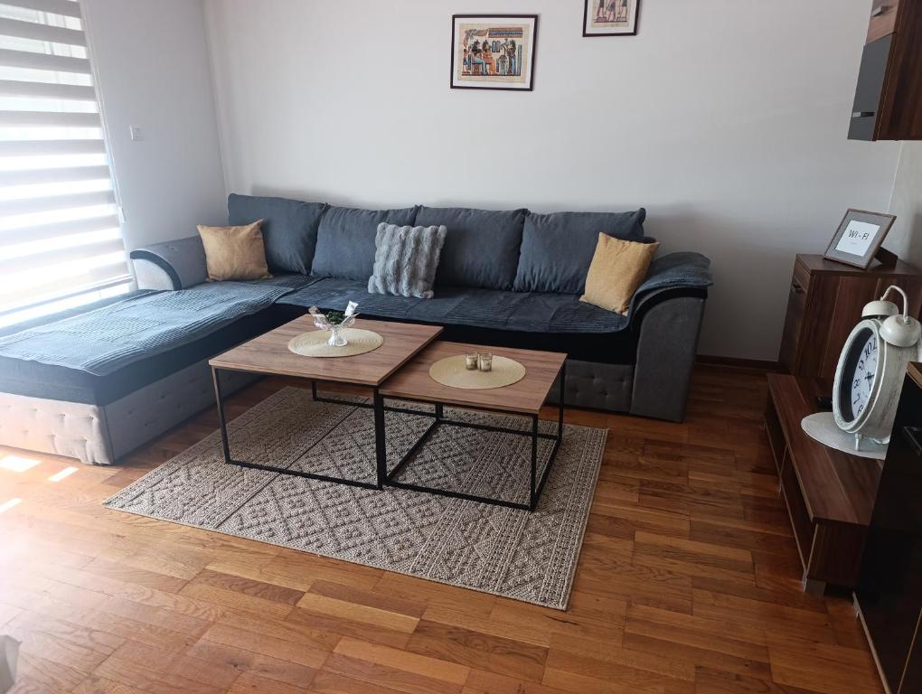 a living room with a blue couch and a table at Apartman TEA Trebinje in Trebinje