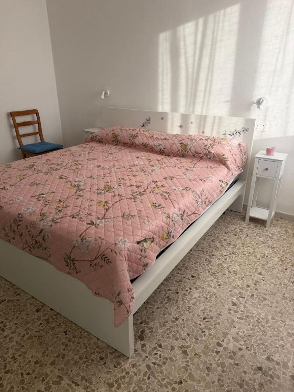 a bedroom with a bed with a pink comforter at Binario1 Lake View in Lierna