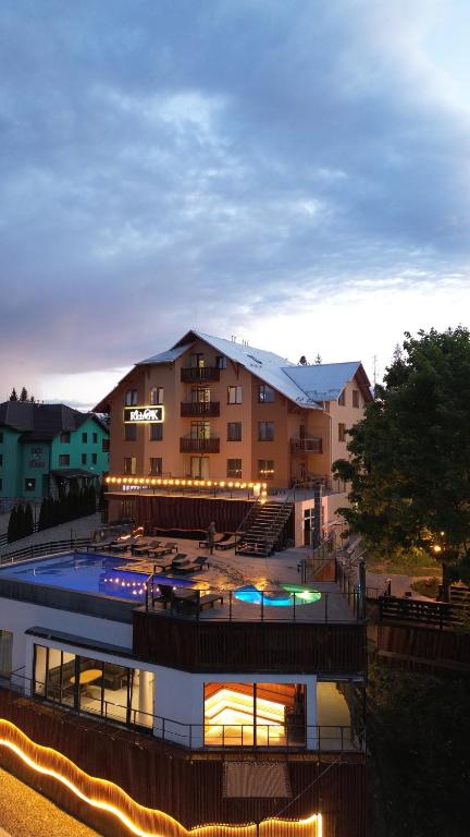 a building with a swimming pool in front of it at Rich OAK - готель з відкритим панорамний басейном in Yablunytsya