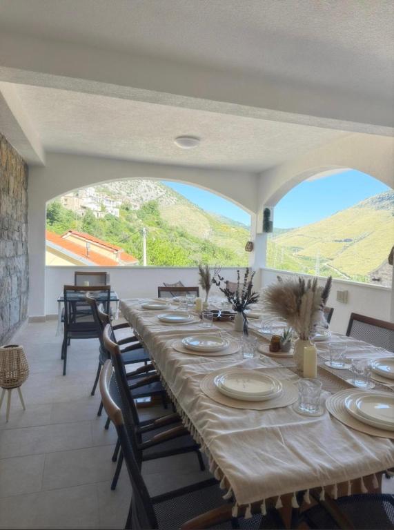 a dining room with a long table and some chairs at Villa with stunning Mountain Views and Authentic Croatian Stone House near Split and Sea in Žrnovnica