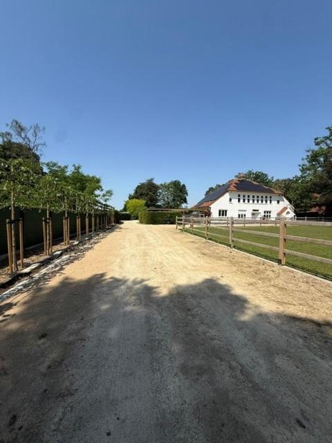 a dirt road with a fence and a house at Berckenhof in Heusden - Zolder