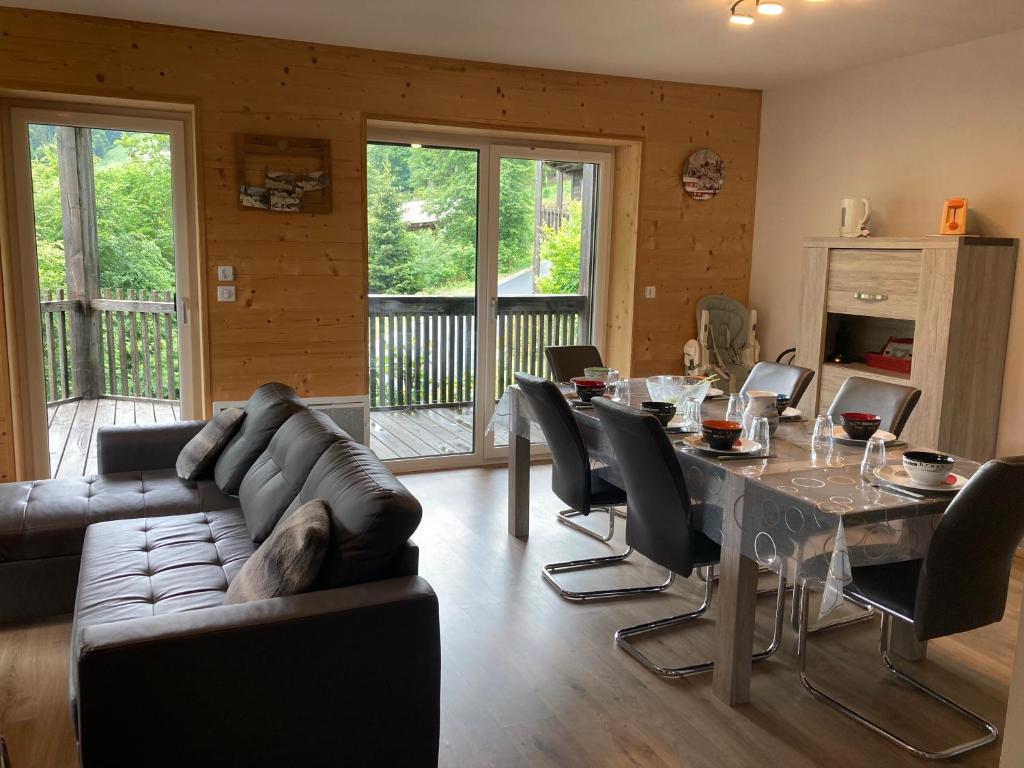 a living room with a couch and a table with chairs at Les Estives R-2G in Le Lioran