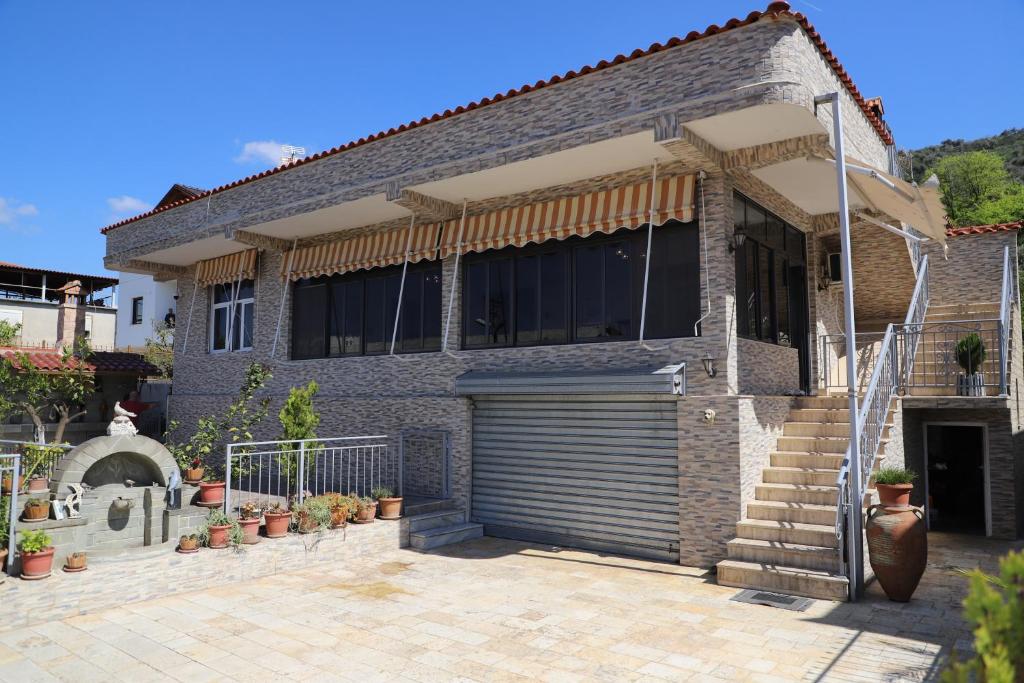 a brick house with a garage door and stairs at A&B Berat in Berat