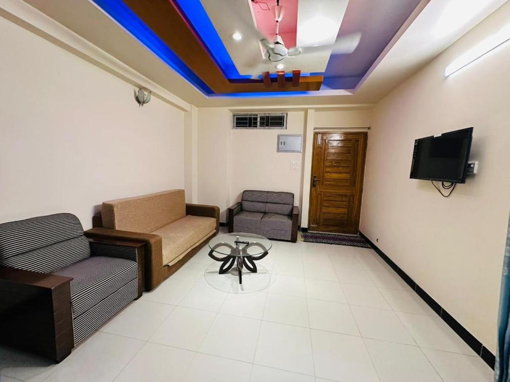 a living room with a couch and a tv at Vacation House a Service Apartment in Cox's Bazar