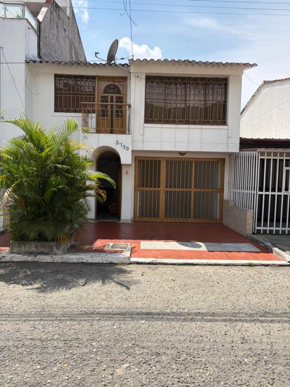 a white house with a palm tree in front of it at El Palmar in Palmira