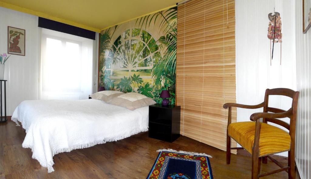 a bedroom with a white bed and a painting on the wall at Lina et Anaë in Saint-Nabor