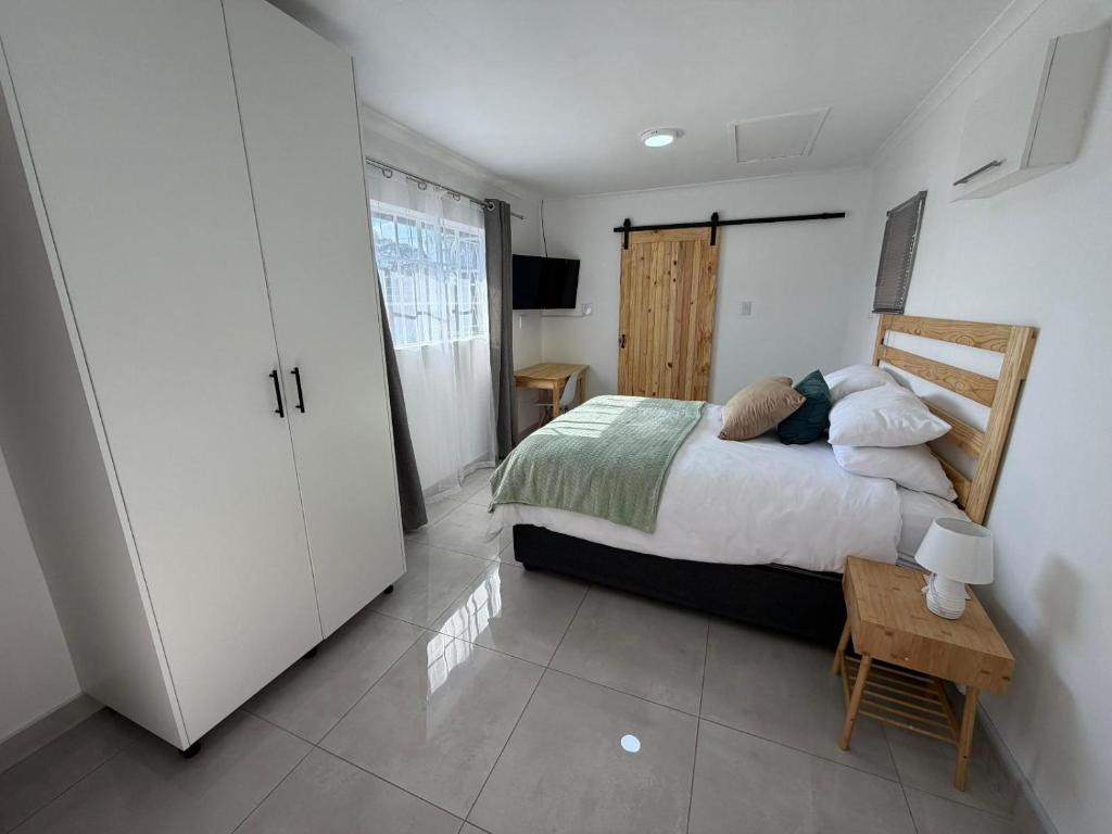 a bedroom with a bed and a table and a tv at 47 on Cleland in Pietermaritzburg
