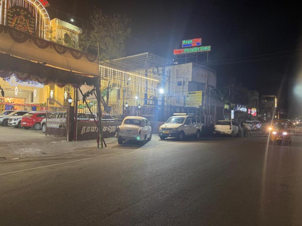 a city street at night with cars parked on the street at Raya's Executive Homes in Kumbakonam