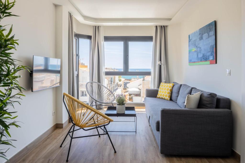 a living room with a couch and a chair at Be Mate Málaga Playa in Málaga