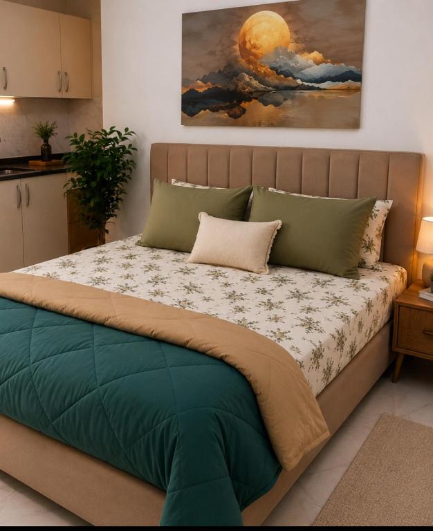 a bed in a bedroom with a painting on the wall at CoCo Nest Cozy Modern Studio Near Mamsha Beach & Airport in Hurghada