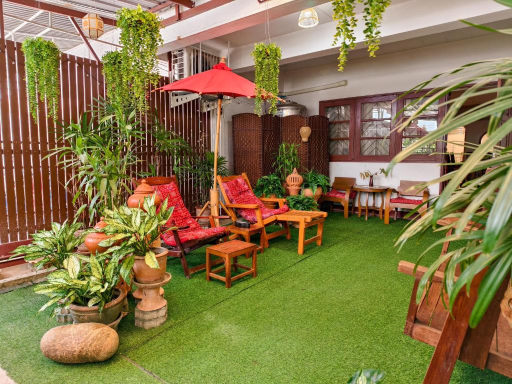 a patio with chairs and tables and plants at Aphilapa House in Chiang Mai