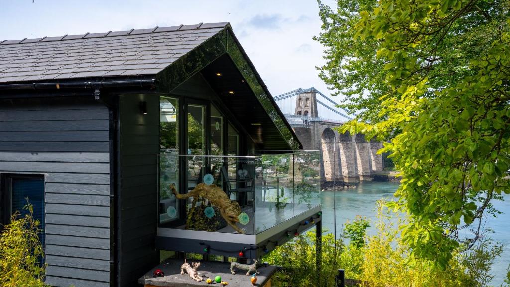 a glass house on the river with a bear in it at Bilidowcar in Menai Bridge