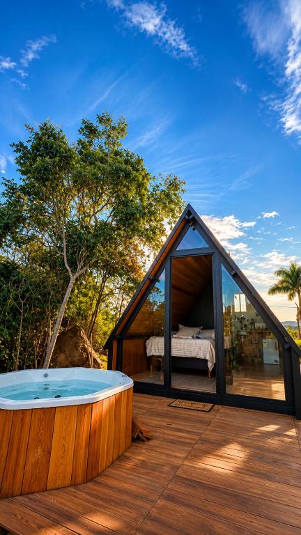 a house with a hot tub on a deck at Chalé Suiço Diniz e Ferreira in Contagem