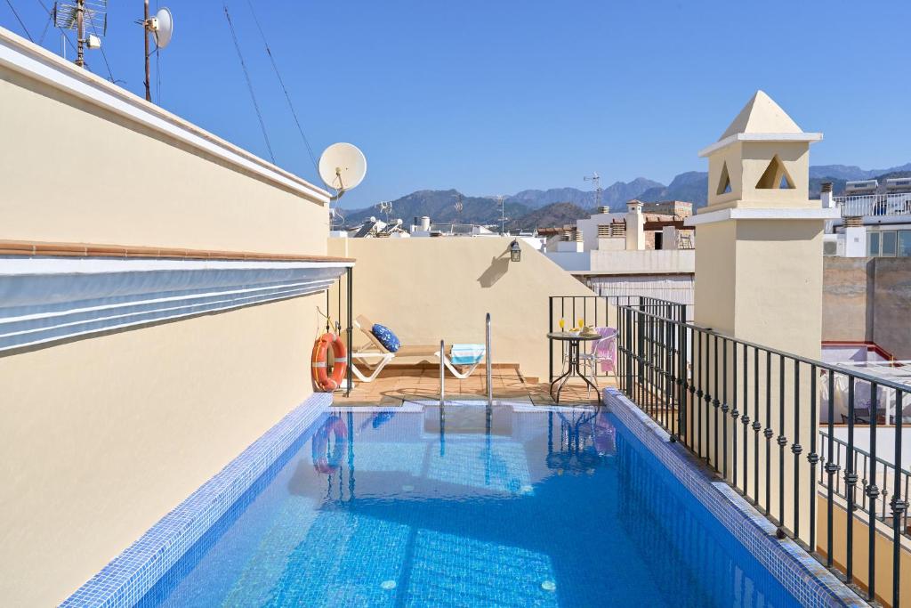 a swimming pool on the roof of a house at Apartamentos Nerjaluna in Nerja