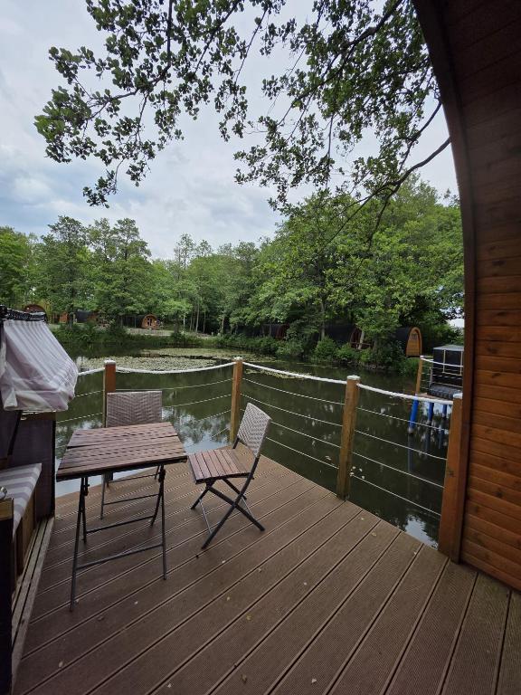 a wooden deck with a picnic table and two chairs at 21 Premium Camping Pod "Baltrum" in Silberstedt