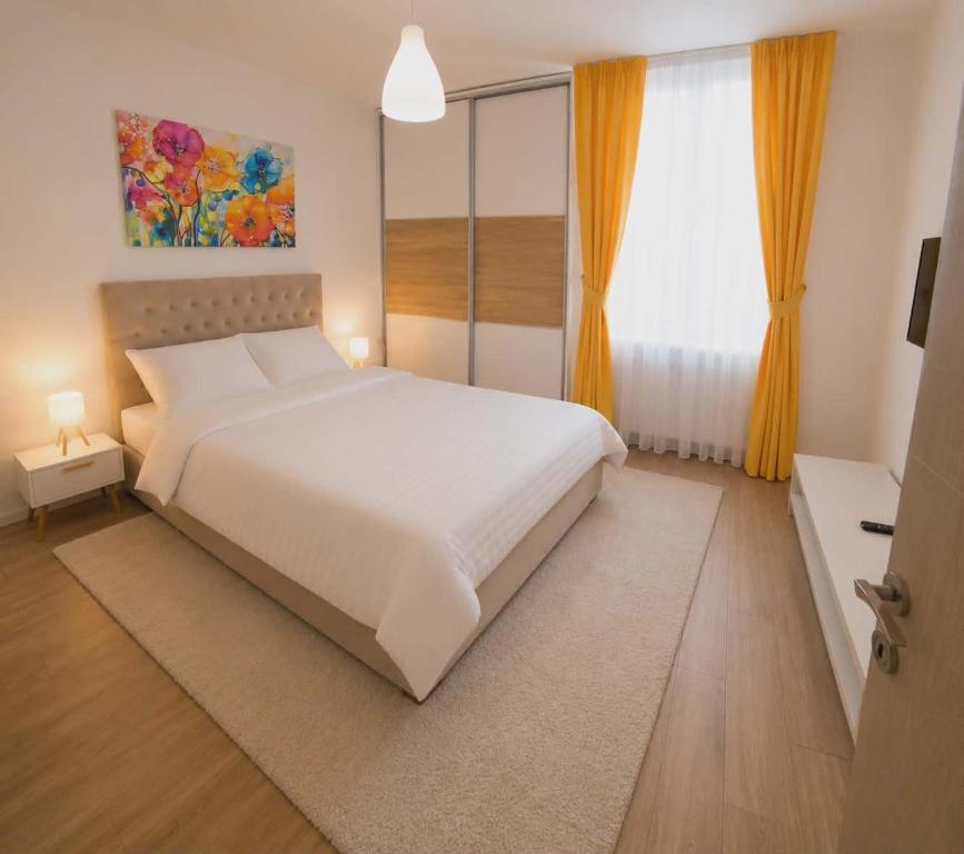 a bedroom with a large white bed and a window at MM Central Apartment with Parking in Skopje