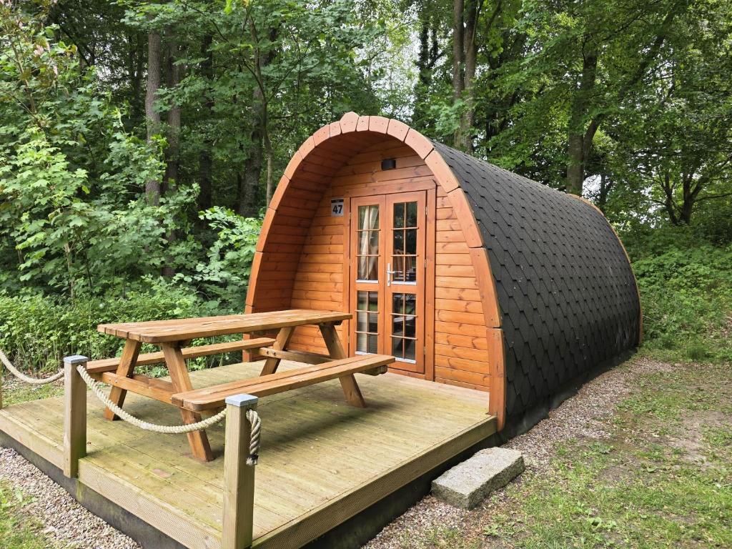 a small house with a picnic table and a bench at 47 Camping Pod "Flut" in Silberstedt