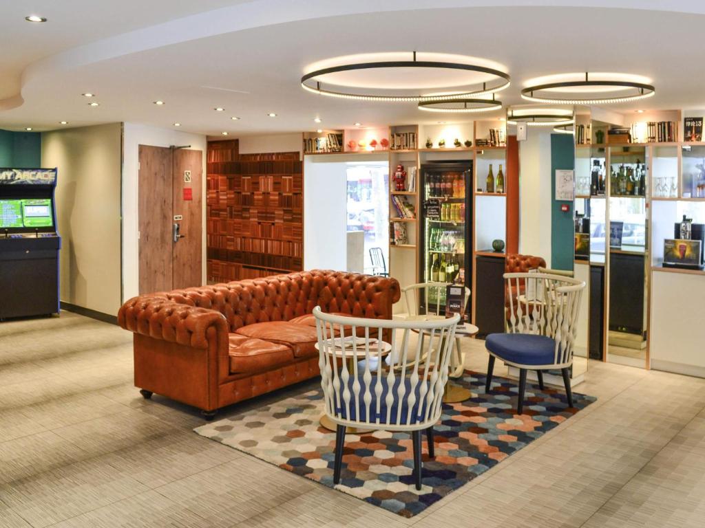 a living room with a couch and a table and chairs at ibis Paris Gare de Lyon Diderot in Paris
