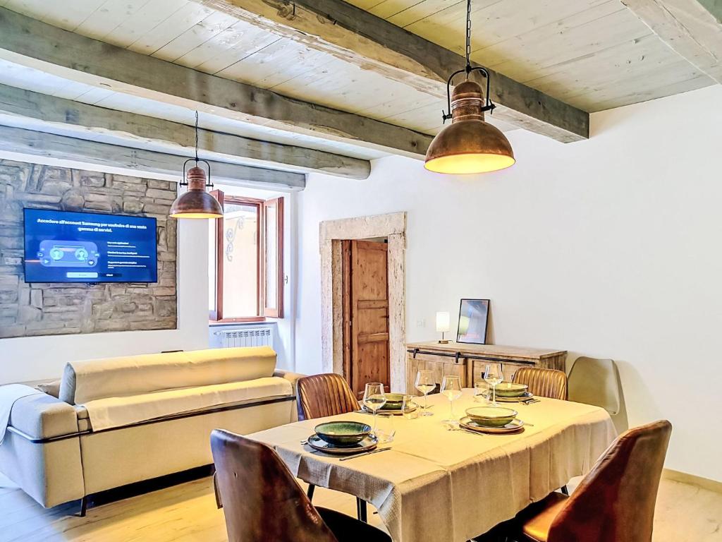 a dining room with a table and a couch at Apartment Novecento by Interhome in Monterotondo