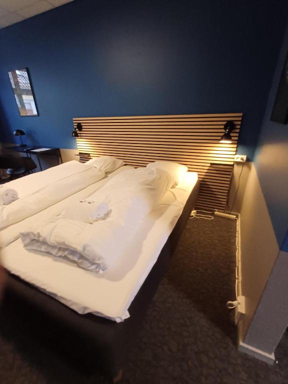 a bedroom with a large bed with white sheets at Double Room 9 in Saeby in Sæby