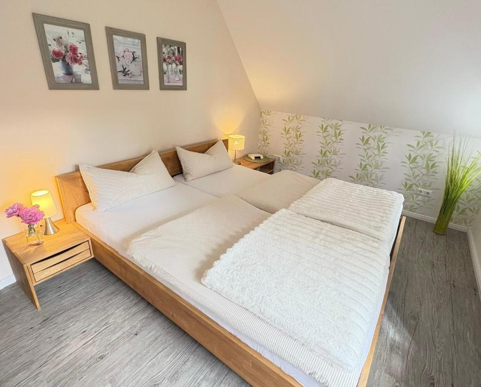 a bedroom with a large bed with white sheets at Alte Schule Breese in Dannenberg