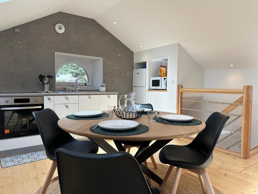 a kitchen and dining room with a wooden table and chairs at Maison Fontanille in Le Puy-en-Velay