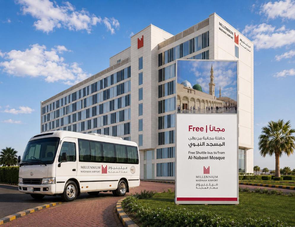a white bus parked in front of a building at Millennium Madinah Airport in Medina