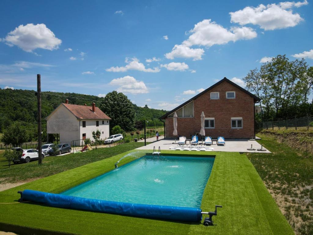a large swimming pool in the yard of a house at VIKENDICA GARAŠKI KUTAK in Arandelovac