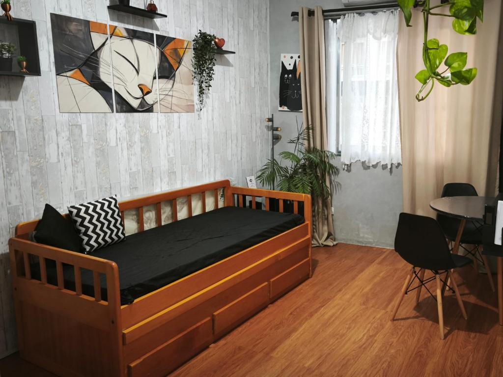 a bedroom with a bed with a cat picture on the wall at Cantinho da Jessi in São Vicente
